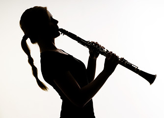 Image showing Female Musician in Silhouette Practices Woodwind Technique on Cl