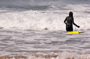 Image showing Young Woman Female Wake Board Rider Wades out Sea Surf