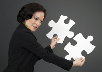 Image showing Woman Working With Two Large Jigsaw Puzzle Pieces