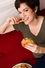 Image showing Happy Healthy Young Adult Woman Eats Fast Food Cheesburger Lunch