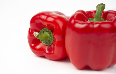 Image showing Pair of Bright Fresh Red Peppers Food Sits on White