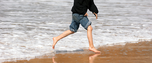 Image showing Young Boy Running Feet Ocean Beach Surf Crashing Sea Foam