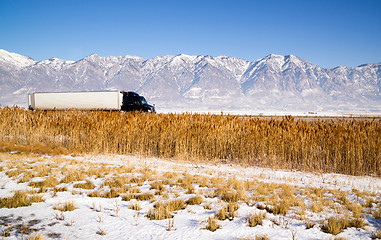 Image showing Semi Truck Speeding down Utah Highway Winter Wasatch Mountains