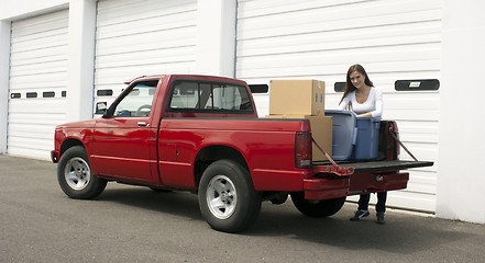 Image showing Attractive Female Loads Red Pickup Truck Storage Facility Moving