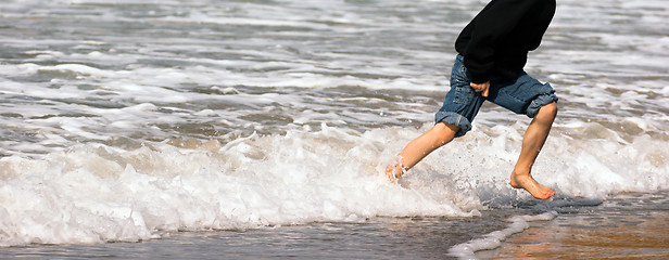 Image showing Young Boy Running Feet Ocean Beach Surf Crashing Sea Foam