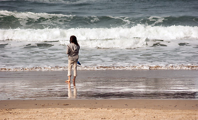 Image showing Young Girl Looks Out Ocean Surf Sand Shovel West Coast