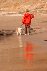 Image showing Young Boy Bright Orange Barefoot Walking Dog Ocean Beach