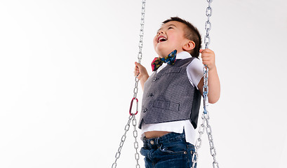 Image showing Happy Young Boy Plays Swing Suspended Moving Laughing Child Play