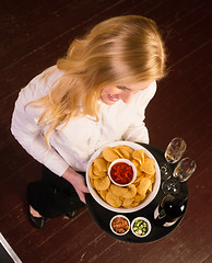Image showing Young Attractive Female Server Brings Tray Chips Salsa Bean Appe