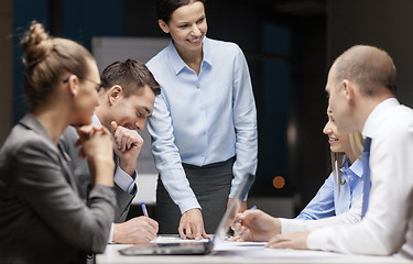 Image showing smiling female boss talking to business team