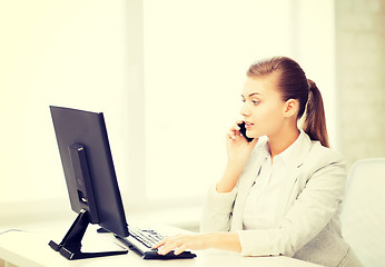 Image showing businesswoman with smartphone in office