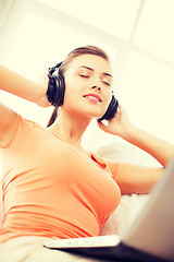 Image showing woman with headphones and laptop at home