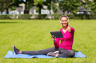 Image showing smiling woman with tablet pc outdoors