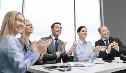 Image showing business team with laptop clapping hands