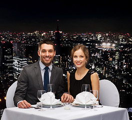 Image showing smiling couple holding hands at restaurant