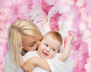 Image showing happy mother kissing smiling baby