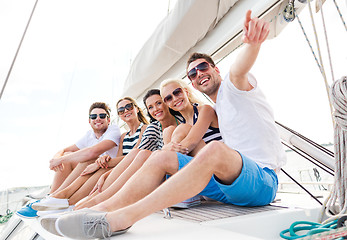 Image showing smiling friends sitting on yacht deck