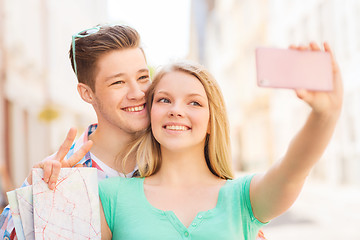 Image showing smiling couple with smartphone in city