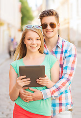 Image showing smiling couple with tablet pc in city