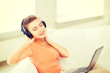 Image showing woman with headphones and laptop at home