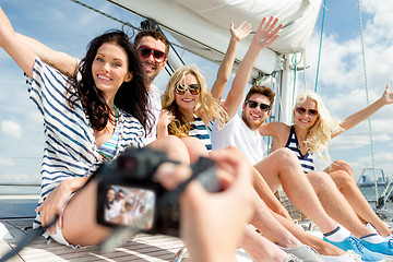 Image showing smiling friends photographing on yacht