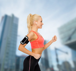 Image showing sporty woman running with smartphone and earphones