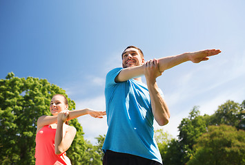 Image showing smiling couple stretching outdoors