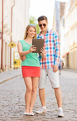 Image showing smiling couple with tablet pc in city