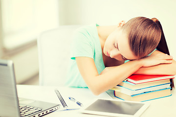 Image showing tired student sleeping on stock of books