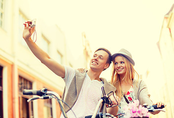 Image showing couple with bicycles taking photo with camera
