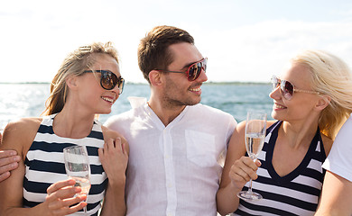 Image showing smiling friends with glasses of champagne on yacht