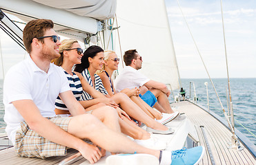 Image showing smiling friends sitting on yacht deck