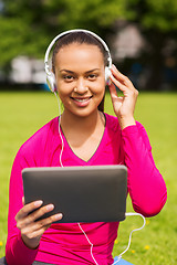 Image showing smiling woman with tablet pc outdoors