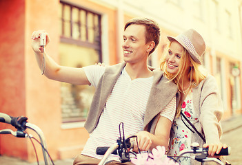 Image showing couple with bicycles taking photo with camera