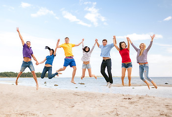 Image showing group of friends jumping on the beach