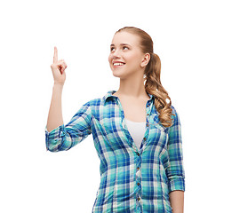 Image showing smiling young woman pinting finger up