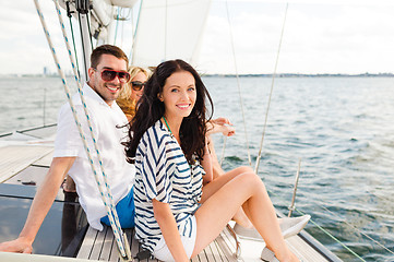 Image showing smiling friends sitting on yacht deck