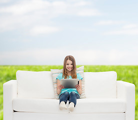 Image showing little girl sitting on sofa with tablet pc