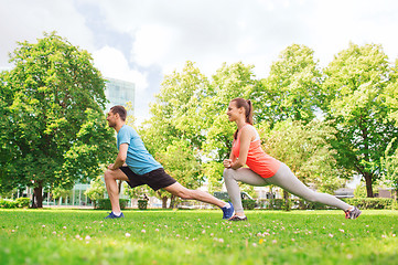 Image showing smiling couple stretching outdoors