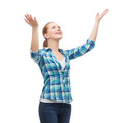 Image showing smiling young woman looking up