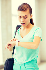 Image showing surprised student girl looking at clock