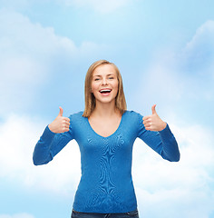 Image showing smiling girl in casual clothes showing thumbs up