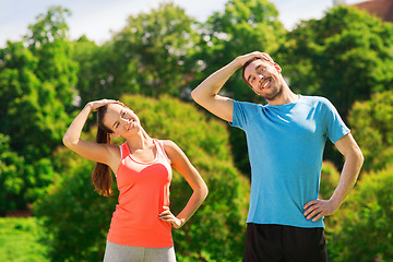 Image showing smiling couple stretching outdoors