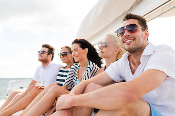 Image showing smiling friends sitting on yacht deck