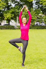 Image showing smiling woman exercising outdoors