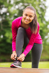 Image showing smiling woman exercising outdoors