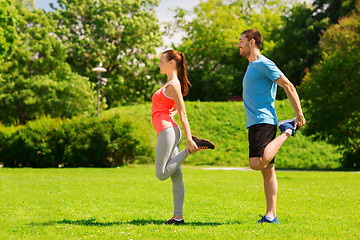 Image showing smiling couple stretching outdoors