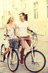 Image showing smiling couple with bicycles in the city