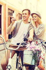 Image showing couple with bicycles and smartphone in the city