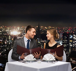 Image showing smiling couple with menus at restaurant